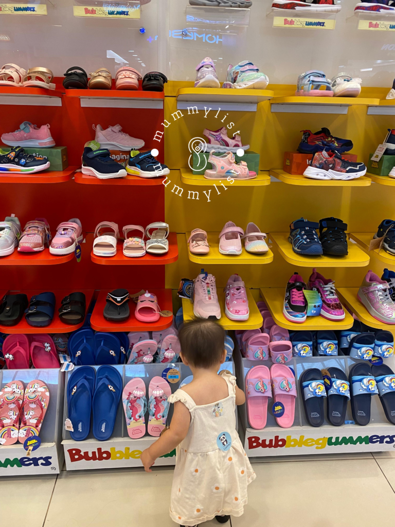 Baby looking at a shelf of shoes